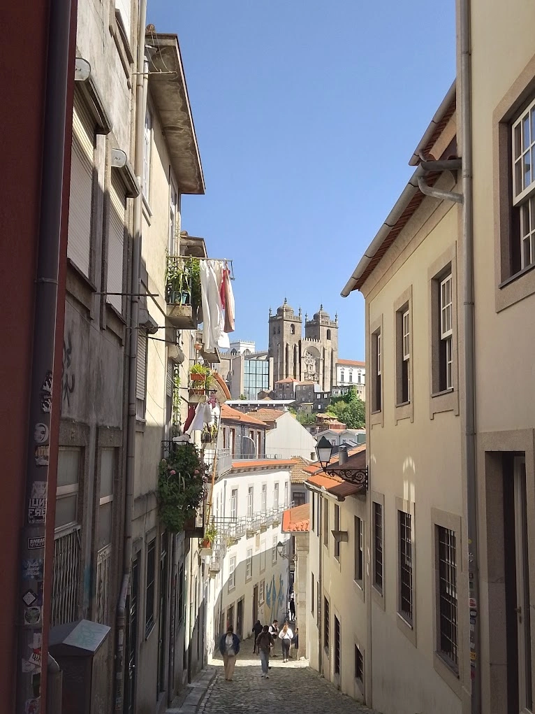 Narrow cobblestone alley in Porto framing the Sé Cathedral towers