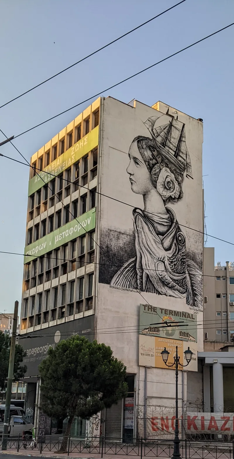 Large street art mural of a classical figure on a building facade in Athens
