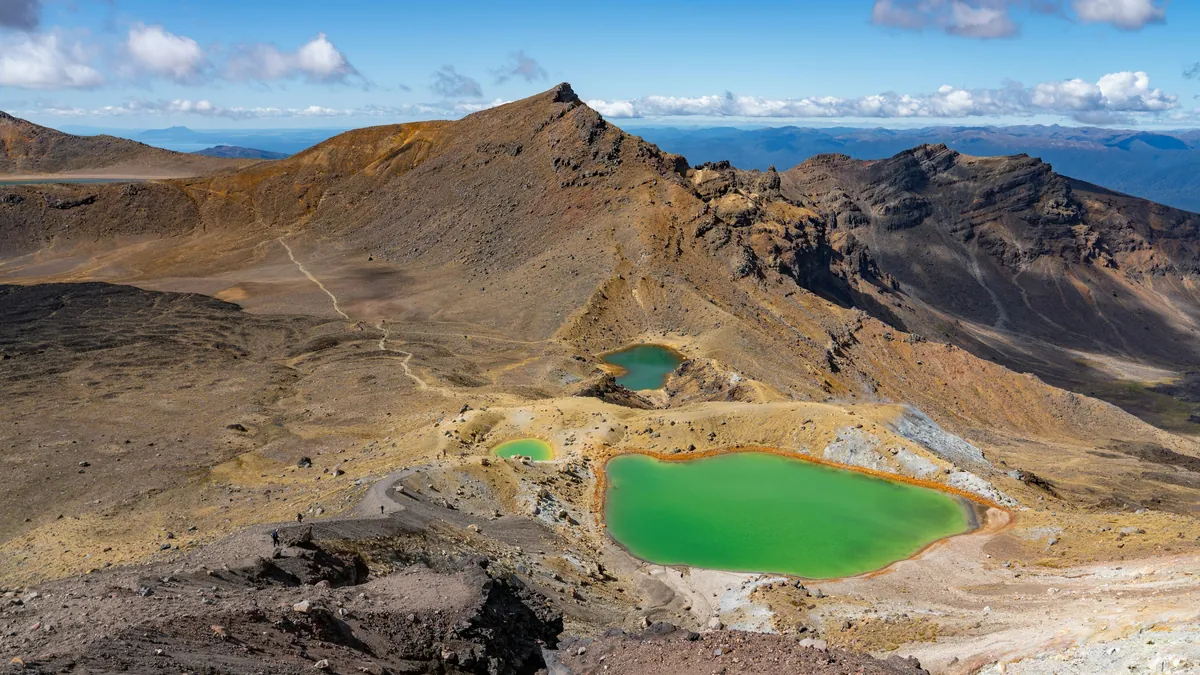Hiker looking over the Emerald Lakes on Tongariro Alpine Crossing, New Zealand