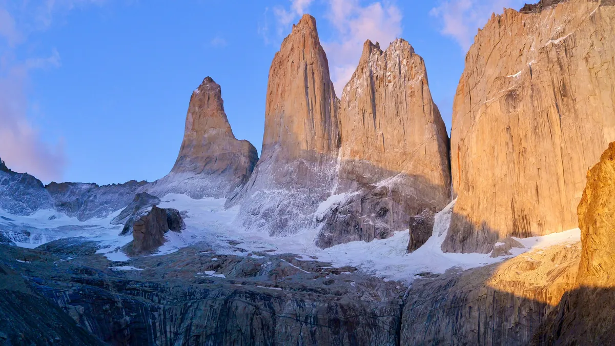 Three granite towers of Torres del Paine reflected in a lake at sunrise, Chilean Patagonia