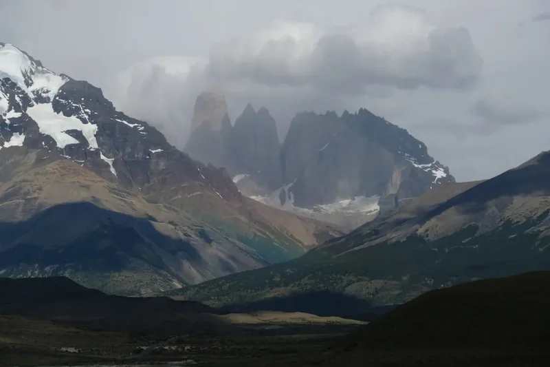 the mountains are covered in snow and clouds