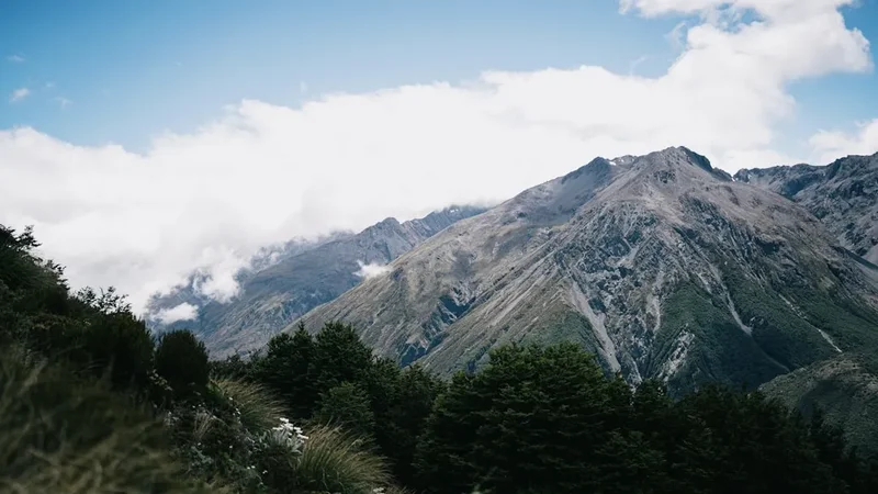 A view of a mountain range with clouds in the sky