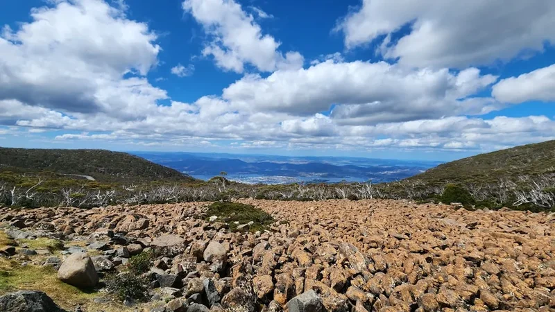 a rocky landscape with a blue sky and clouds