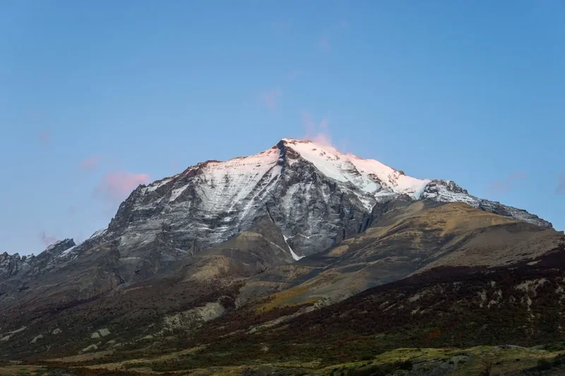 Snow-capped mountain peak under a clear, blue sky.