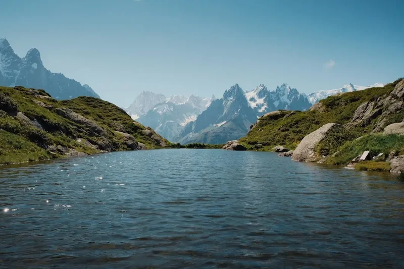 A body of water with mountains in the background