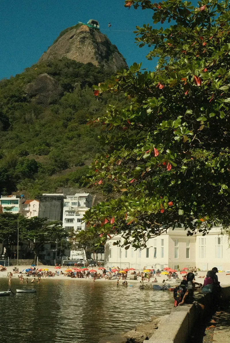 A group of people sitting on a bench next to a body of water