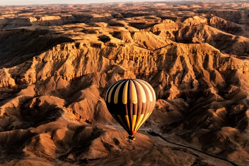 a hot air balloon flying over a desert landscape