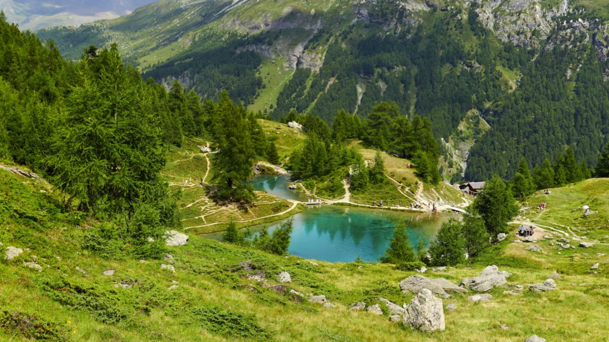 green and brown mountains near blue lake under white clouds during daytime
