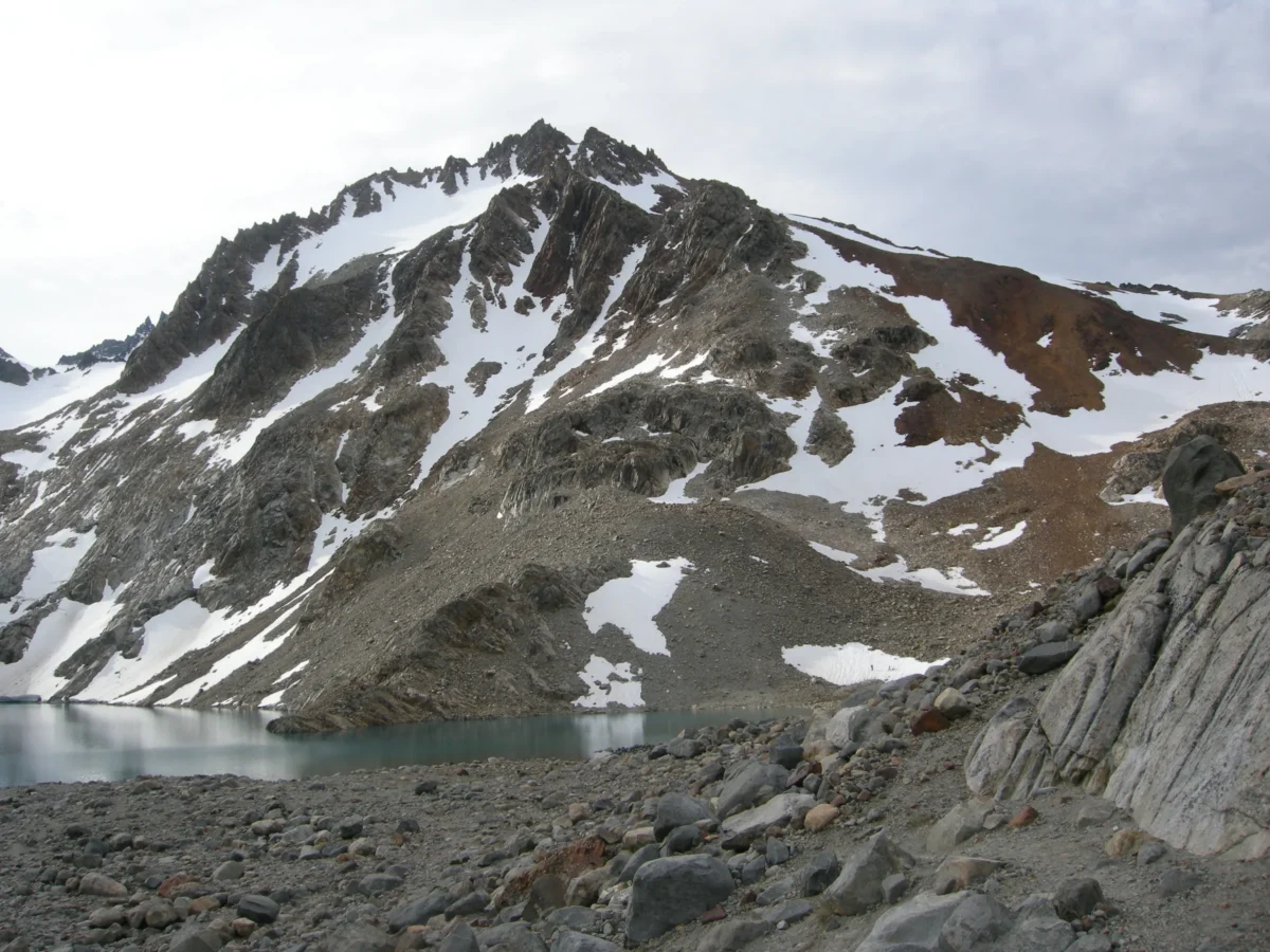 A trail in the mountains with snow on the top