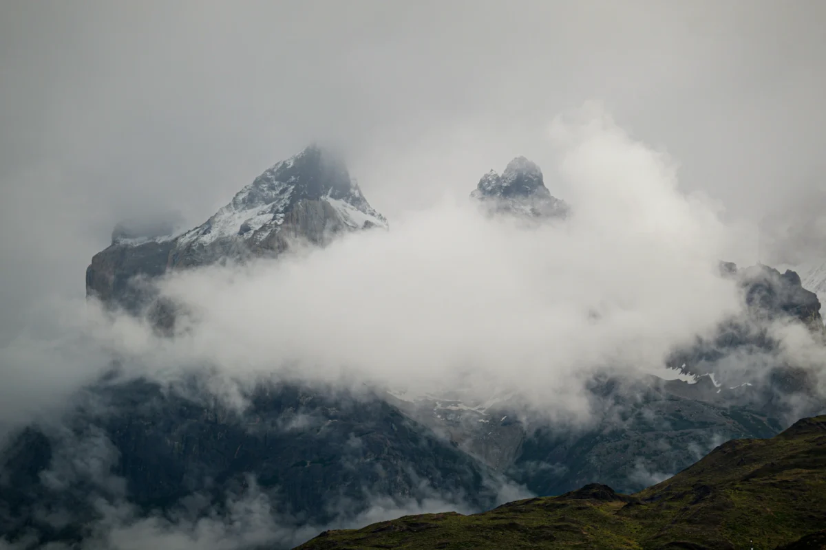 A view of a mountain with clouds in the sky