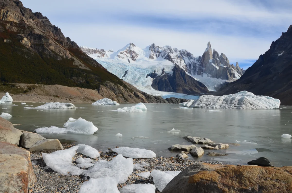 A lake surrounded by rocks and snow covered mountains
