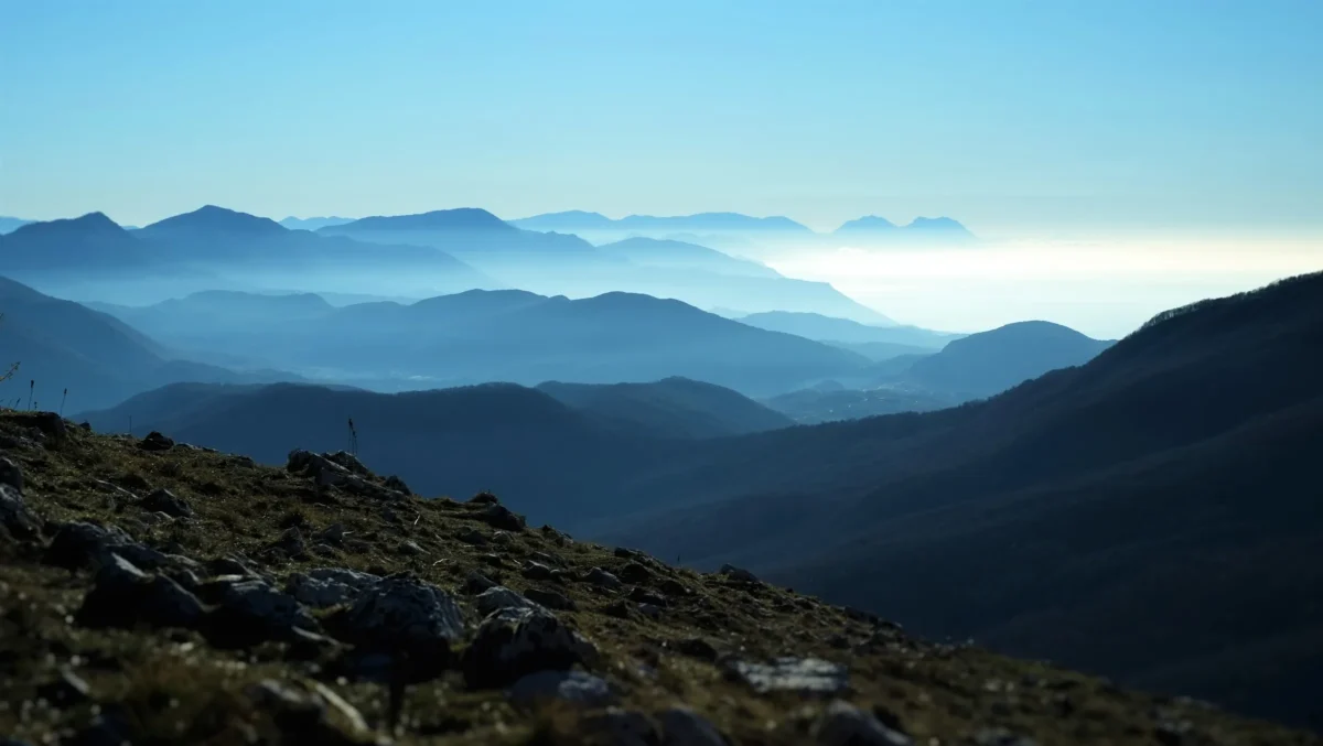 A mountain range with snow capped mountains in the background