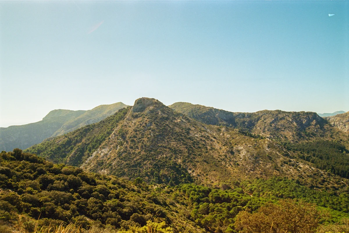 Mountains rise under a clear, blue sky.