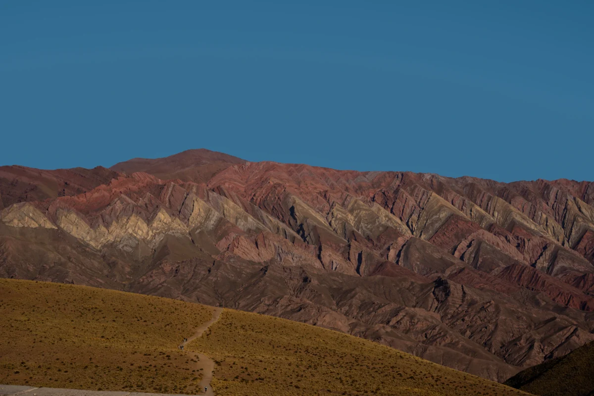 Colorful striped mountains under a clear blue sky.