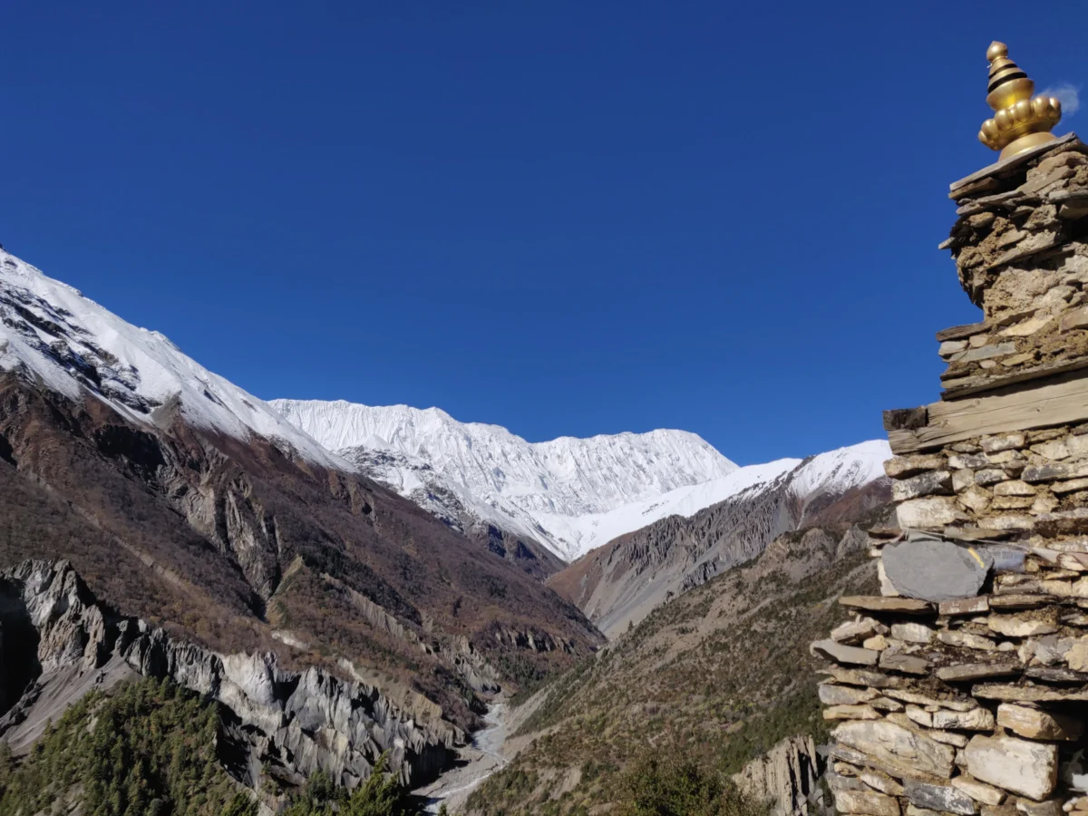 a view of a mountain range with a golden statue on top
