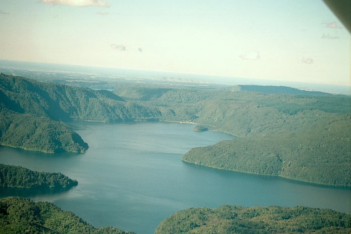 A scenic roadside view of mountains and a lake.