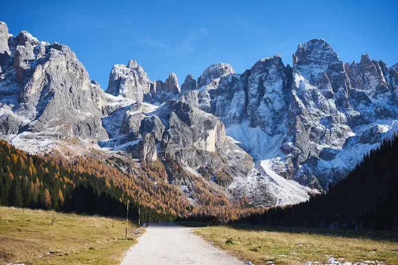 Snow-capped jagged mountain range under a clear blue sky.