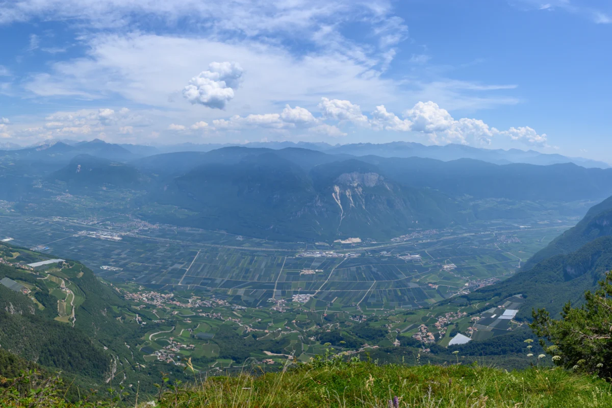a scenic view of a valley with mountains in the background