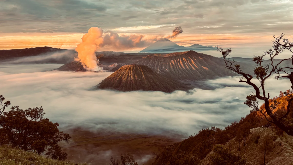 Golden sunrise over a sea of clouds and mountains.