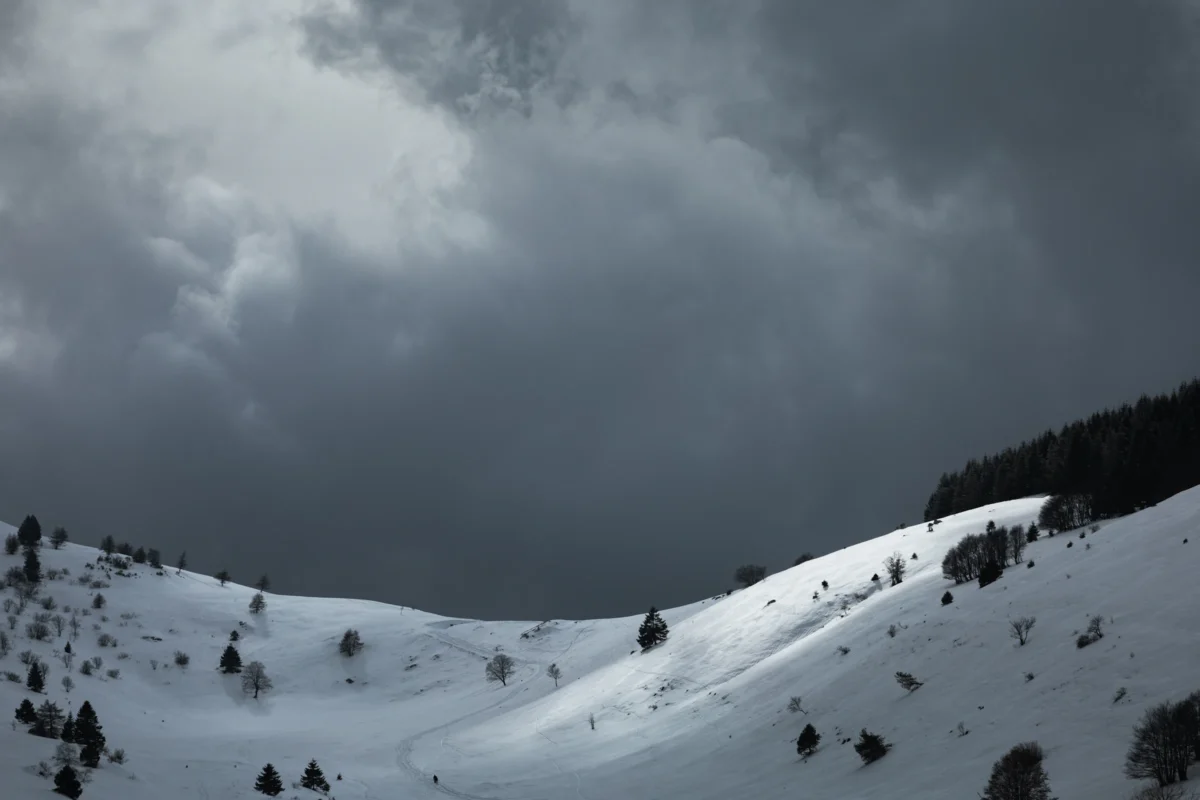 A snow covered mountain under a cloudy sky