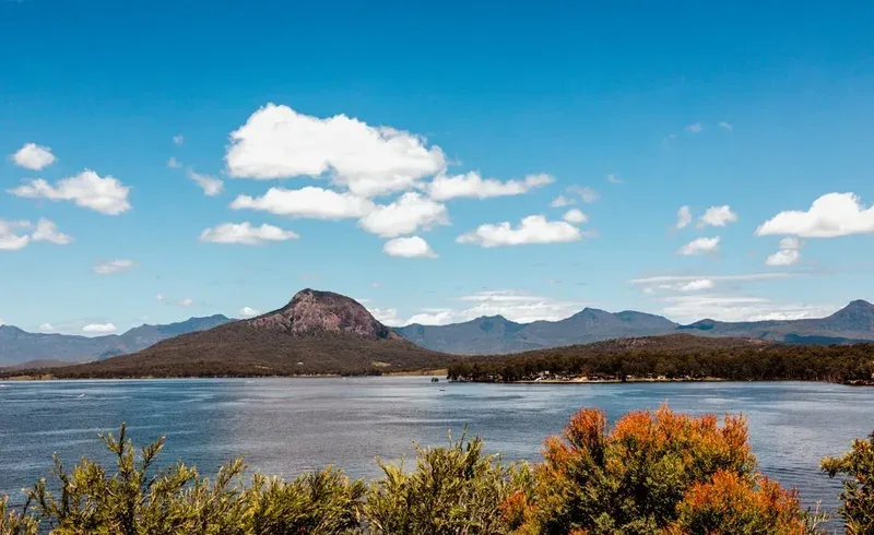 Mountains and a lake are beneath a blue sky.