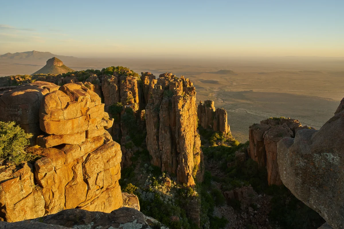 a view of a rocky outcropping with trees and mountains in the background