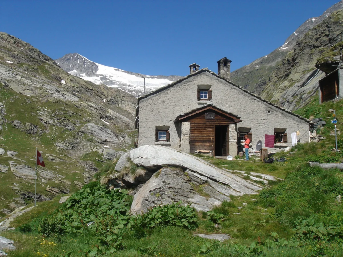 A path leading to a village with a mountain in the background