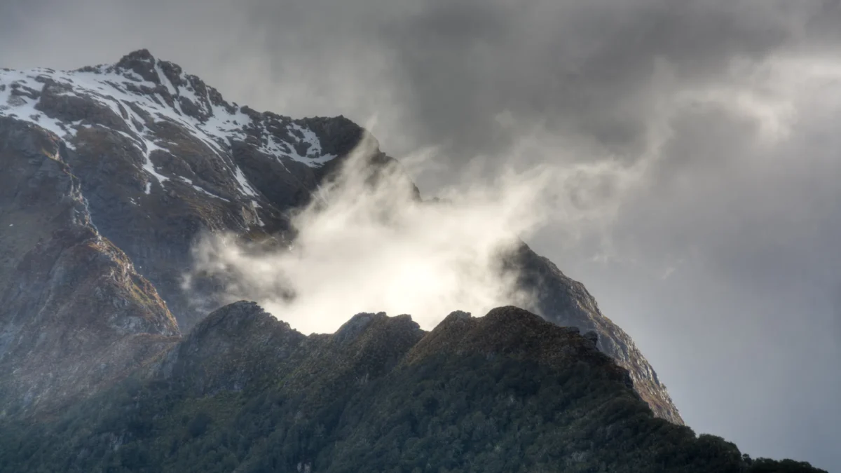 Rugged mountains flank a grassy valley under a blue sky.