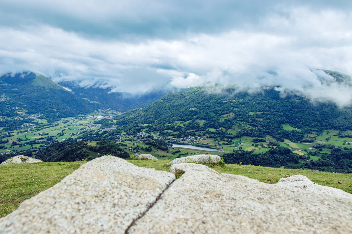 A rocky outcropping with a valley in the background