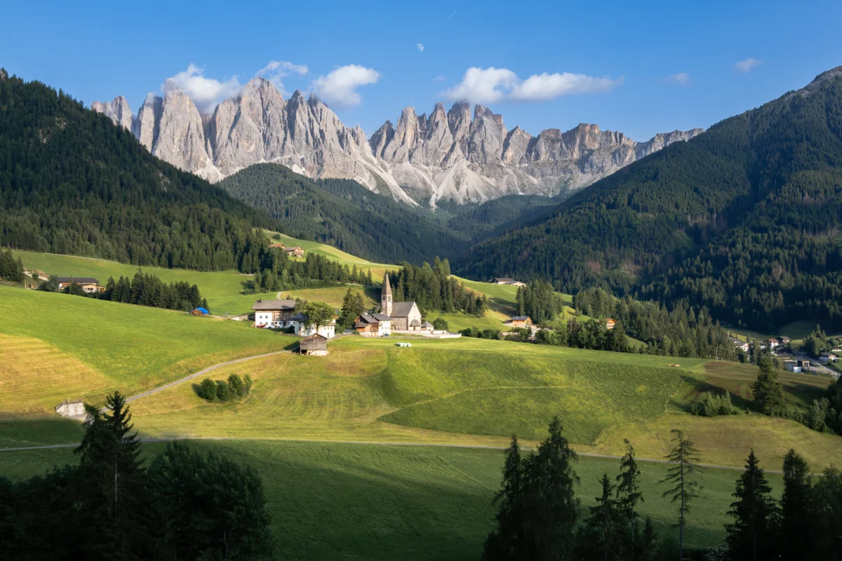 A picturesque mountain village is under cloudy peaks.