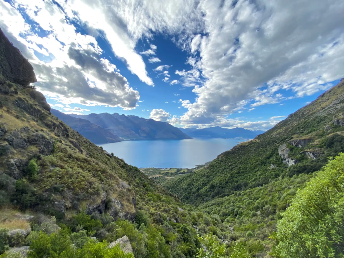 Snow-capped mountains rise above a wide river.