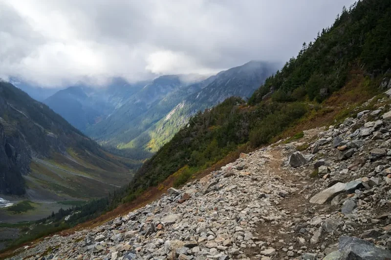 A rocky trail with a mountain in the background
