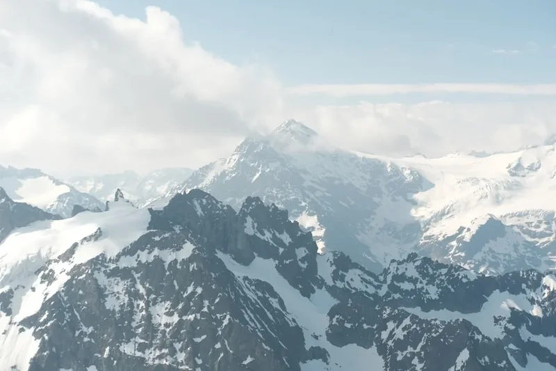 a view of a snowy mountain range from an airplane