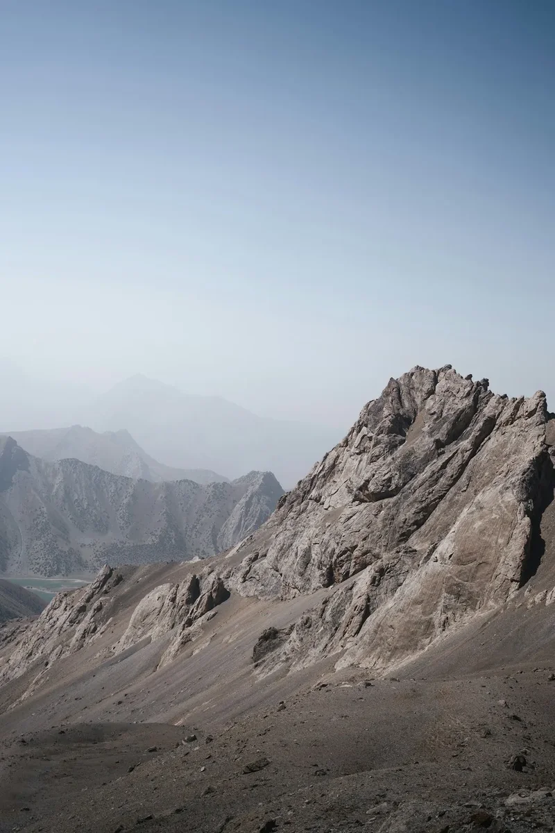 A large mountain with a few rocks on top of it
