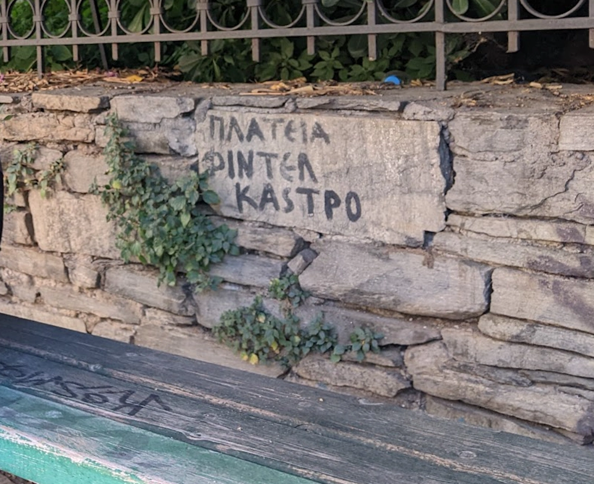 Hand-painted ΠΛΑΤΕΙΑ ΦΙΝΤΕΛ ΚΑΣΤΡΟ (Fidel Castro Square) on an old stone wall, Thessaloniki