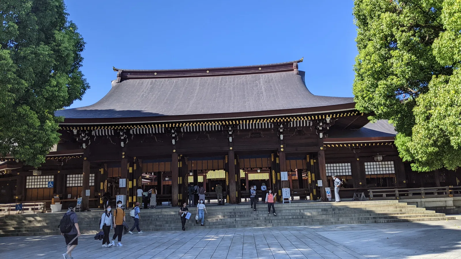 Large wooden shrine hall with a sweeping dark roof and open courtyard in Tokyo