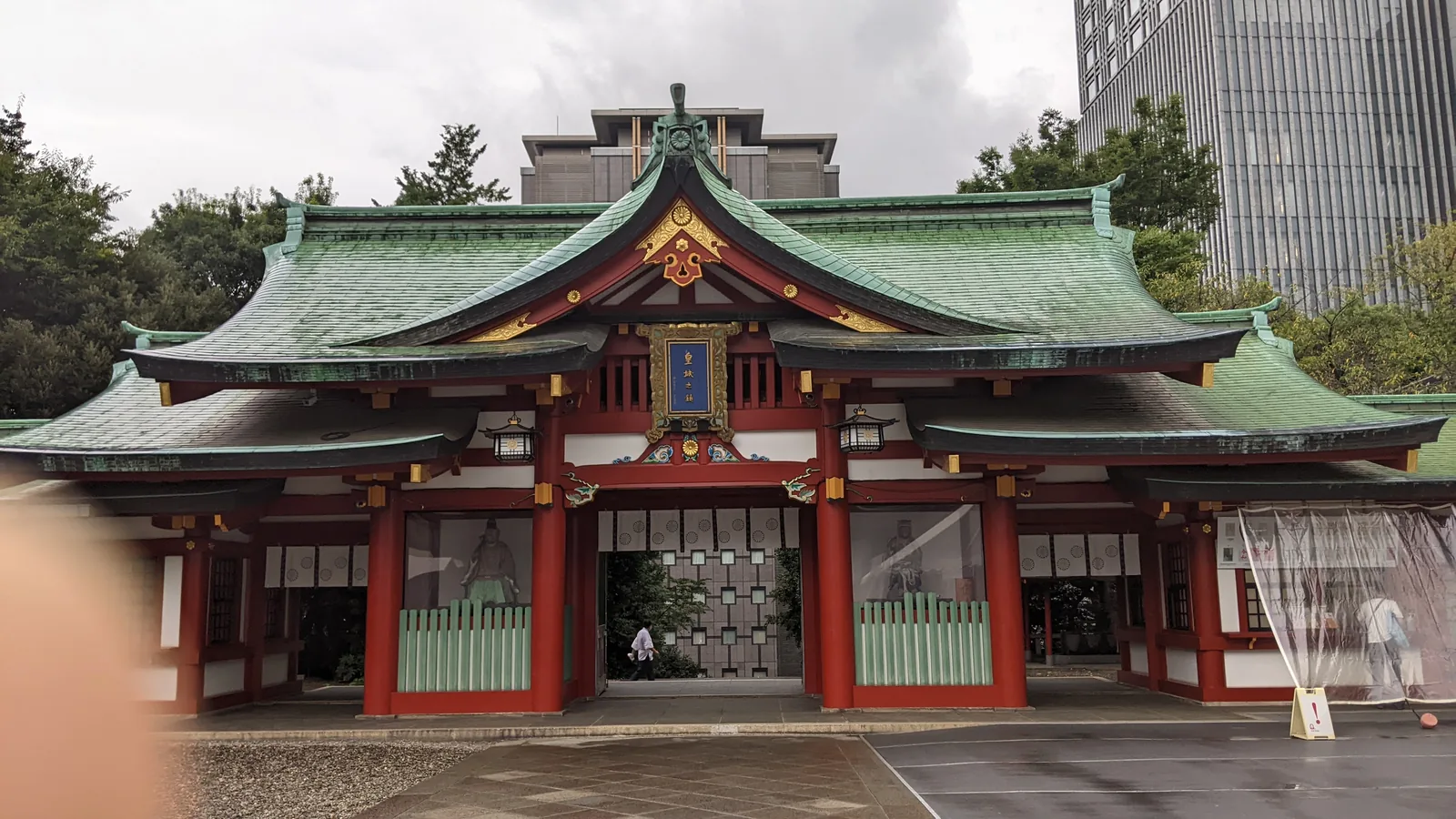 Bright red and gold Shinto shrine facade with green tiled roof in Tokyo