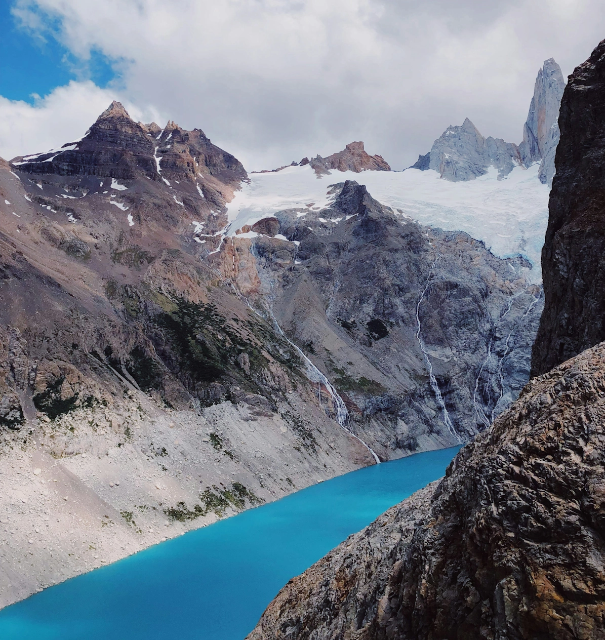 Turquoise waters of Laguna de los Tres with the dramatic jagged granite spires of Monte Fitz Roy in Los Glaciares National Park, Argentina