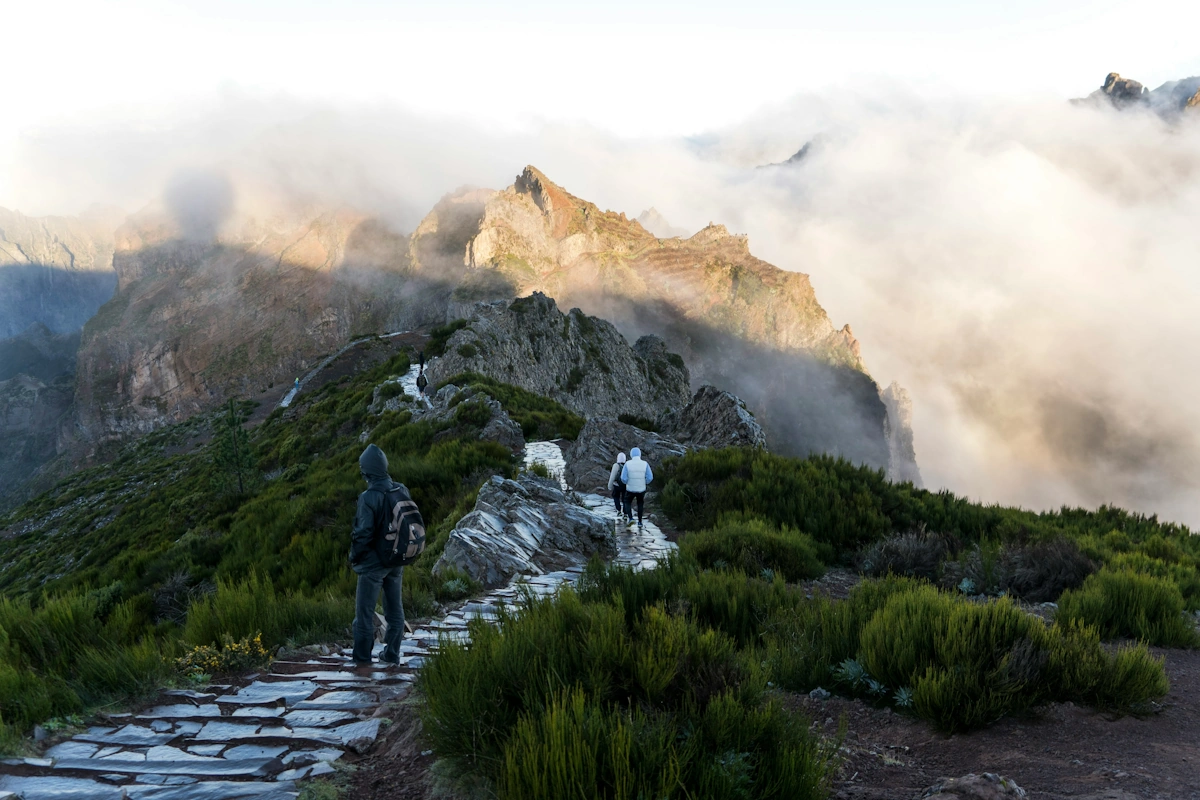 Hiker climbing a rocky mountain trail along the route from Pico Areeiro to Pico Ruivo in Madeira
