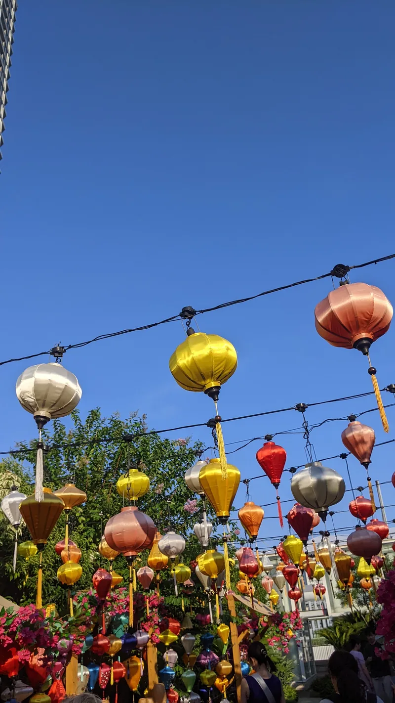 Colourful paper lanterns and streamers strung against a deep blue dusk sky in Yokohama