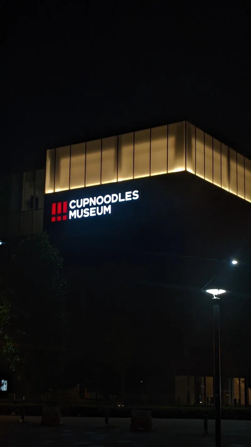The CupNoodles Museum building illuminated against the night sky in Yokohama
