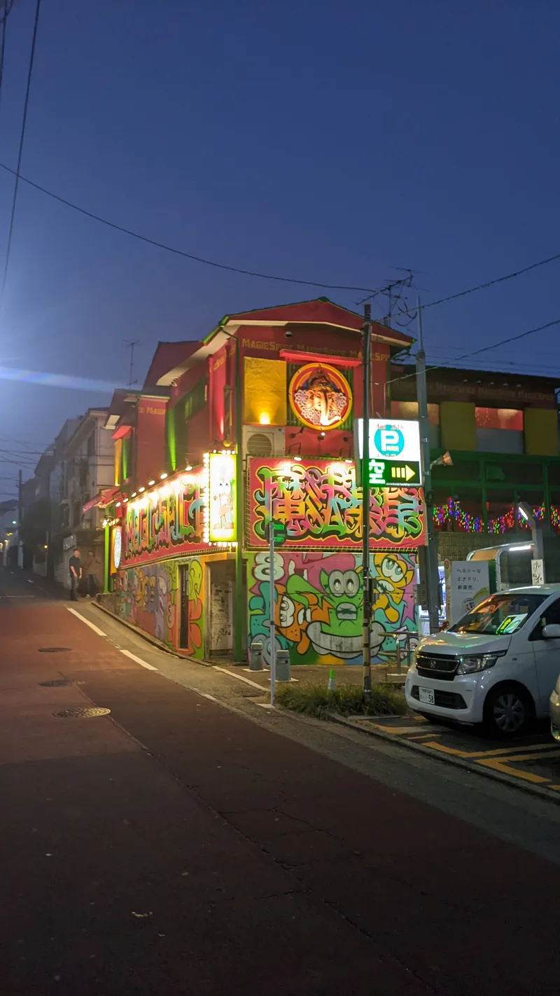 Lantern-lit night street with a brightly painted shopfront in Yokohama